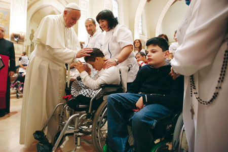 Paus Franciscus zegent jonge gehandicapten in Assisi.