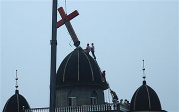 Het grote kruis op een kerk in de havenstad Wenzhou wordt met behulp van een kraan verwijderd.