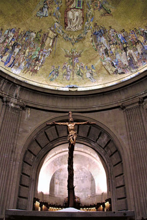 De met mozaïeken beklede koepel van de basiliek en het grote kruis gebeeldhouwd door een bekeerde republikein.